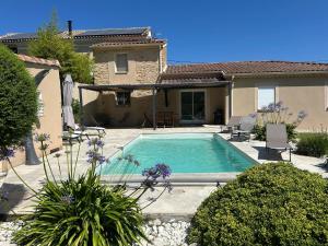 a swimming pool in the backyard of a house at Villa Elara provençale avec piscine 4 étoiles in Sarrians