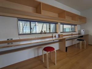 a room with a desk and two stools in a room at ファミリーロッジ つつじ in Sakaiminato