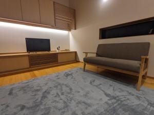 a living room with a couch and a flat screen tv at ファミリーロッジ つつじ in Sakaiminato