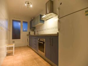 cocina con armarios azules y nevera en Apartamento Mar Menor II, en Tarifa