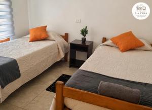 a bedroom with two beds and a night stand at Cabañas nuevas La Peña in Taltal