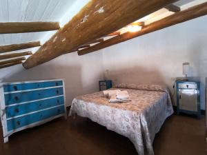 a bedroom with a bed and a blue dresser at La casetta del masso in Sorano