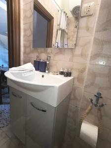 a bathroom with a white sink and a mirror at La casetta del masso in Sorano +11 photos