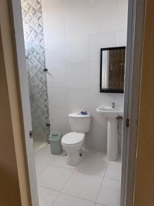 ein weißes Badezimmer mit Toilette und Waschbecken in der Unterkunft Edificio Ramírez 01 in Baní