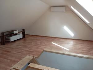 an empty room with a white wall and wooden floors at Apartmán BB in Čížkrajice