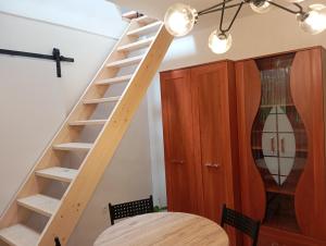 a wooden staircase in a room with a table at Apartmán BB in Čížkrajice
