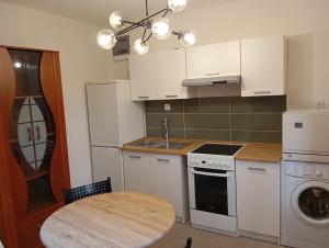 a kitchen with white cabinets and a table and a sink at Apartmán BB in Čížkrajice