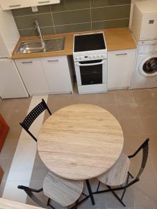 a kitchen with a wooden table with two chairs at Apartmán BB in Čížkrajice