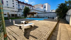 a courtyard with a swimming pool and a building at Apartamento com Lareira a 5 Min da Feirinha do Alto - Piscina e Sauna in Teresópolis