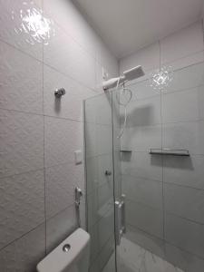 a bathroom with a glass shower with a toilet at Pousada Flor de Sal in Macau