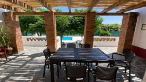 a black table and chairs on a patio with a pool at Tapada Poço das Canas in Redondo