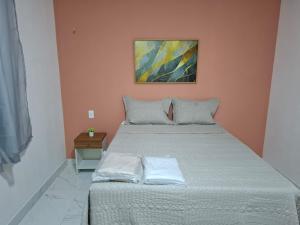 a bed in a bedroom with a painting on the wall at Pousada Flor de Sal in Macau