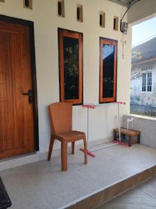 a room with a chair and a door at Sherin Homestay in Pulau Sarang +2 photos
