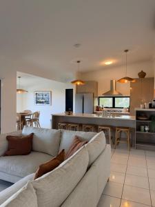 a living room with a couch and a kitchen at The Dune House in Tangalooma