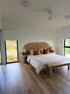 a bedroom with a large bed with a wooden floor at The Dune House in Tangalooma