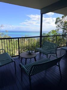 a porch with two chairs and a table on a balcony at The Dune House in Tangalooma