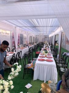 a long row of tables in a white tent at Antopom Heights & Suites in Sunyani