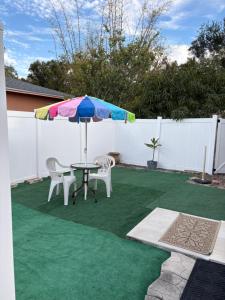 a patio with a table and chairs and an umbrella at Oasis of the forest in Brandon