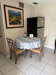 a table with two chairs and a refrigerator in a room at Oasis of the forest in Brandon
