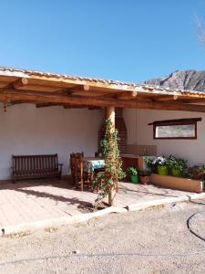 a wooden pergola with a table and a bench at Cabaña Samka in Maimará