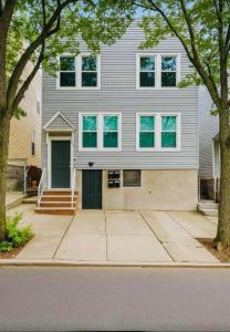 a gray house with a black door on a street at Modern & Spacious Apartment 15 Min to NYC Near MetLife & American Dream in Jersey City