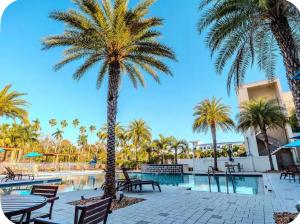 a palm tree next to a pool at a resort at The Caloosa Retreat in Fort Myers