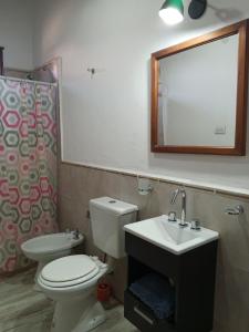a bathroom with a toilet and a sink and a mirror at Cabaña Samka in Maimará