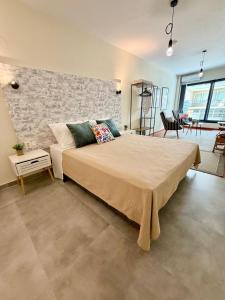 a bedroom with a large bed and a brick wall at 11 Diamond Drive, Luxury Bright & Quiet City Center Loft, Easy Access in Kavála