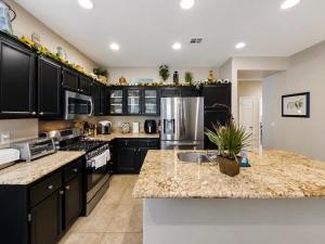 a kitchen with black cabinets and a granite counter top at Amazing Grace Vacation Home in Las Vegas