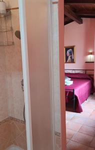 a bedroom with a pink bed and a shower at I Santicelli in Morano Calabro