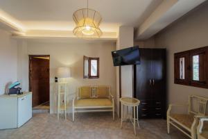 a living room with a tv and a couch and a table at Aspalathos guest rooms in Vathia