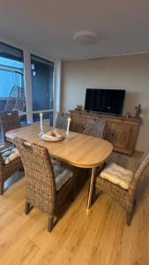 a dining room with a wooden table and chairs at FeWo am Deich im Columbus Center mit Pool und Aufzug in Bremerhaven