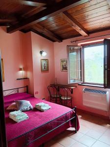 a bedroom with pink walls and a bed with pink sheets at I Santicelli in Morano Calabro