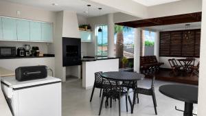 a kitchen and dining room with a table and chairs at Recanto Veraneio - Londrina in Londrina