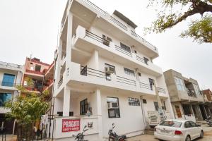 a white building with a car parked in front of it at Hotel O Pragati Inn in Jaipur +24 photos