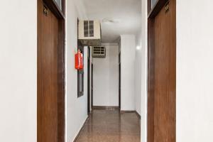 a hallway with white walls and a door and a room at Hotel O Pragati Inn in Jaipur