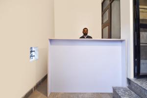 a man standing behind a counter in a building at Hotel O Pragati Inn in Jaipur