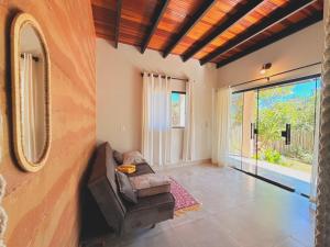 a living room with a couch and a large window at Chalé Baru - Ar-cond - Varanda Pôr do Sol - Cavalcante Goiás in Cavalcante