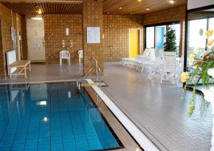 a swimming pool with tables and chairs in a building at FeWo am Deich im Columbus Center mit Pool und Aufzug in Bremerhaven
