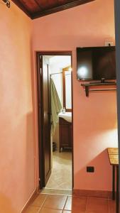 a room with a bathroom with a tv on the wall at I Santicelli in Morano Calabro