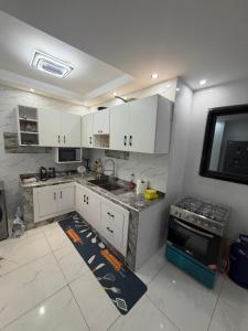 a kitchen with white cabinets and a stove at Résidence sauver in Abidjan