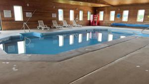 a large swimming pool with chairs in a building at Serena Inn & Suites in Sundance