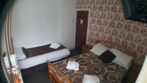 a small room with two beds in a room at The Manuela Rose in Blackpool