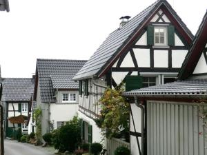 eine Reihe weißer Häuser mit schwarzen Dächern in der Unterkunft "Kramer" - Basement in Hennef