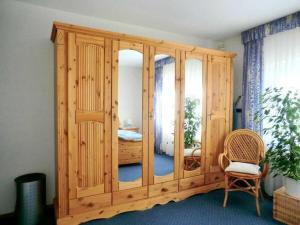 ein großer Holzschrank mit Spiegel in einem Zimmer in der Unterkunft "Kramer" - Basement in Hennef