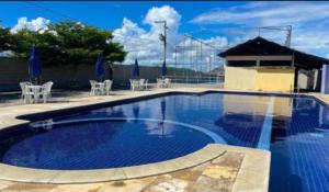 a large swimming pool with chairs and umbrellas at Apartamento em Caruaru 3 quartos completo in Caruaru