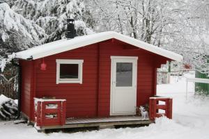 a red shed with a cat sitting in the snow at Puoltikasvaara 3 in Puoltikasvaara