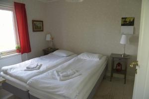 a bedroom with a white bed with two towels on it at Puoltikasvaara 3 in Puoltikasvaara