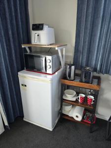 a microwave sitting on top of a refrigerator at Quiet Boutique Generous Breakfast in Palmerston North