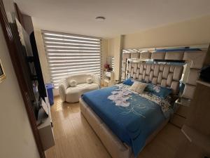 a bedroom with a bed and a chair in it at Alojamiento in Ibarra
